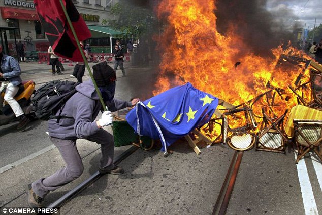 A protester places a EU flag on a bonfire during a riot outside the European Council hall in Gothenburg Sweden. © Associated Newspapers Ltd, The Daily Mail